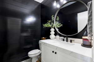 Half bath featuring toilet and vanity