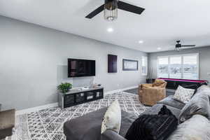 Living area with ceiling fan, baseboards, carpet flooring, and recessed lighting