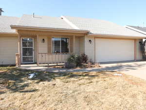 Ranch-style home with a porch, a garage, and a front yard