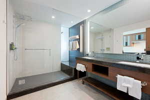 Bathroom with vanity, tile patterned floors, walk in shower, and tasteful backsplash