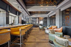 Bar with decorative light fixtures and beam ceiling