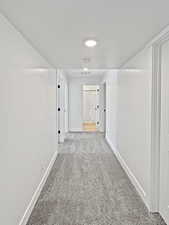 Corridor featuring light carpet