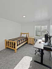 Bedroom featuring carpet flooring and a textured ceiling