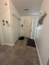 Doorway to outside featuring dark tile patterned flooring and a textured ceiling