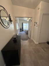 Corridor featuring carpet floors and a textured ceiling