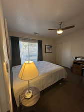 Carpeted bedroom featuring a closet and ceiling fan