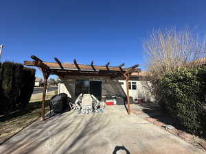 Rear view of house featuring a pergola and a patio area