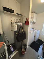 Laundry area featuring cabinets, secured water heater, and washer and clothes dryer