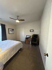 Carpeted bedroom with ceiling fan and a closet