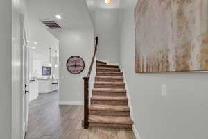 Staircase featuring hardwood / wood-style floors