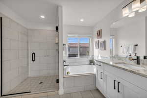 Bathroom featuring vanity and shower with separate bathtub