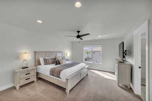 Carpeted bedroom featuring ceiling fan