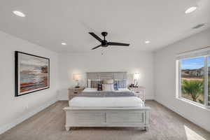 Bedroom with ceiling fan and light carpet