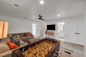 Carpeted living room featuring ceiling fan