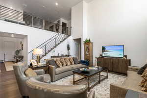 Living room with hardwood / wood-style floors and a high ceiling