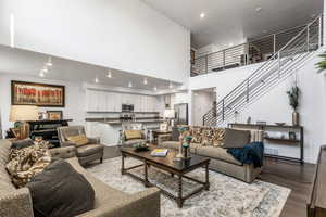 Living room with dark hardwood / wood-style flooring and a high ceiling