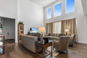 Living room featuring hardwood / wood-style flooring and a towering ceiling