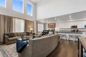 Living room with a high ceiling and dark hardwood / wood-style flooring