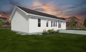 Property exterior at dusk with a mountain view and a lawn