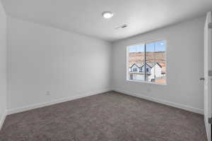 Carpeted empty room featuring a textured ceiling