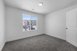 Unfurnished room with a textured ceiling and dark carpet