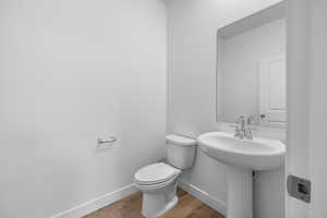 Bathroom with hardwood / wood-style floors, sink, and toilet