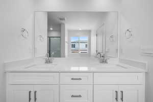 Bathroom with vanity and a shower with shower door