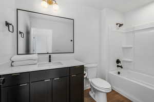 Full bathroom with shower / tub combination, wood-type flooring, toilet, and vanity