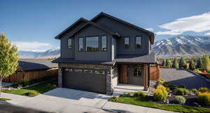 View of front of house featuring concrete driveway, a mountain view, stone siding, an attached garage, and board and batten siding