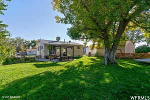 Rear view of property with a lawn, a patio, and central air condition unit