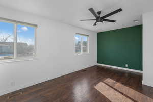 Unfurnished room with dark hardwood / wood-style floors and ceiling fan