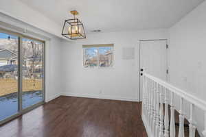 Unfurnished room featuring dark hardwood / wood-style flooring and an inviting chandelier