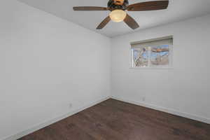 Spare room featuring ceiling fan and dark hardwood / wood-style floors