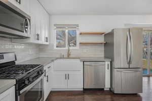 Kitchen with white cabinetry, sink, dark hardwood / wood-style floors, and appliances with stainless steel finishes