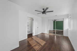 Empty room featuring ceiling fan and dark hardwood / wood-style flooring