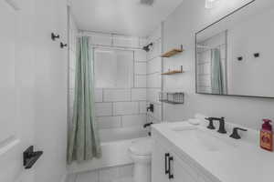 Full bathroom featuring vanity, toilet, tile patterned floors, and shower / bath combo with shower curtain