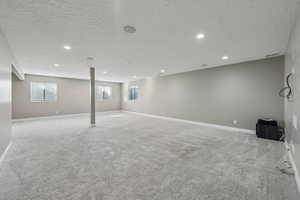 Basement with light carpet and a textured ceiling