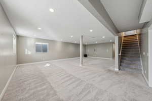 Basement featuring light carpet and a textured ceiling