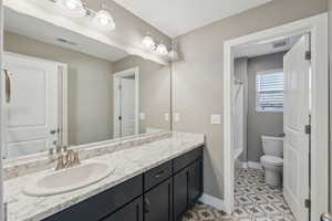 Full bathroom with vanity,  shower combination, and toilet