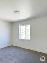 Carpeted empty room with a textured ceiling