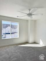 Empty room featuring ceiling fan and carpet flooring