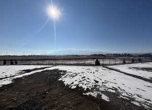 Yard layered in snow with a mountain view and a rural view