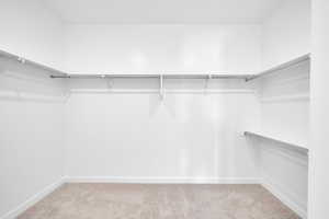 Spacious closet with light colored carpet