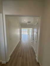 Hall with wood-type flooring and a textured ceiling