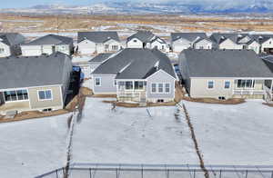 Snowy aerial view featuring a residential view and a mountain view