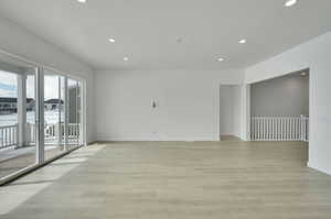 Unfurnished room featuring recessed lighting, light wood-style flooring, baseboards, and a textured ceiling