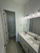 Full bathroom featuring vanity, tile patterned floors, toilet, and washtub / shower combination