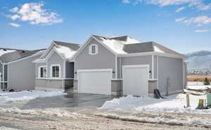 View of front of house with a garage, driveway, a mountain view, and brick siding