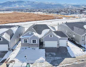 Snowy aerial view featuring a residential view and a mountain view