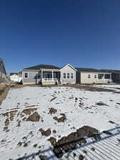 Snow covered rear of property with a porch